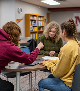 Three students around a table studying