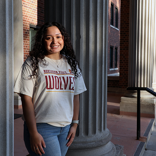 Female student standing next to concrete pillar